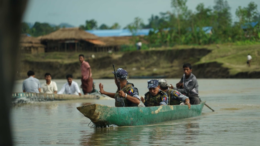 Soldiers cross the river armed with guns in Rakhine region of Myanmar.