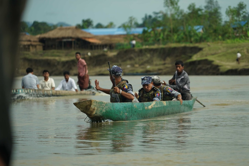Soldiers cross the river armed with guns in Rakhine region of Myanmar.