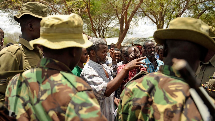 Kenyan security forces talk with residents at a village near Kenya's border town with Somalia on October 15, 2011.