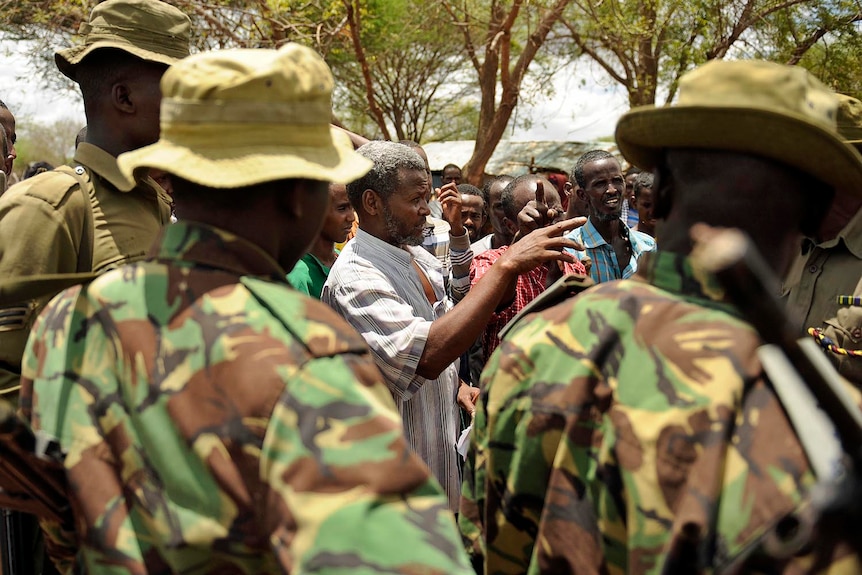 Kenyan security forces talk with residents at a village near Kenya's border town with Somalia on October 15, 2011.