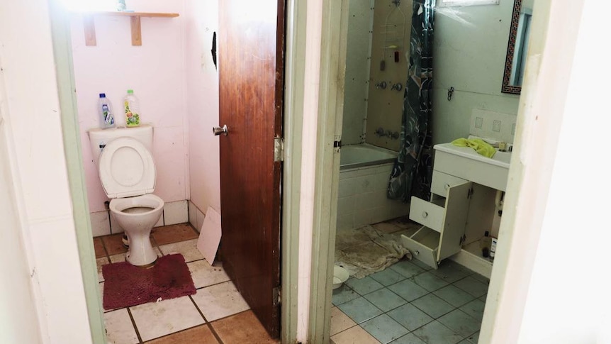 The inside of a house with a very dirty bathroom and toilet.