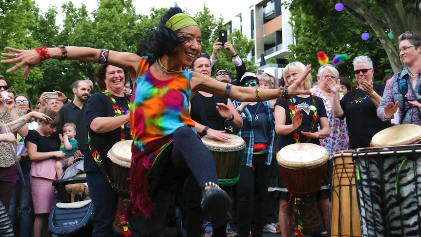 A woman dances in colourful clothing.