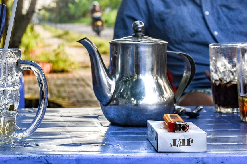 Tea and cigarettes on a table.