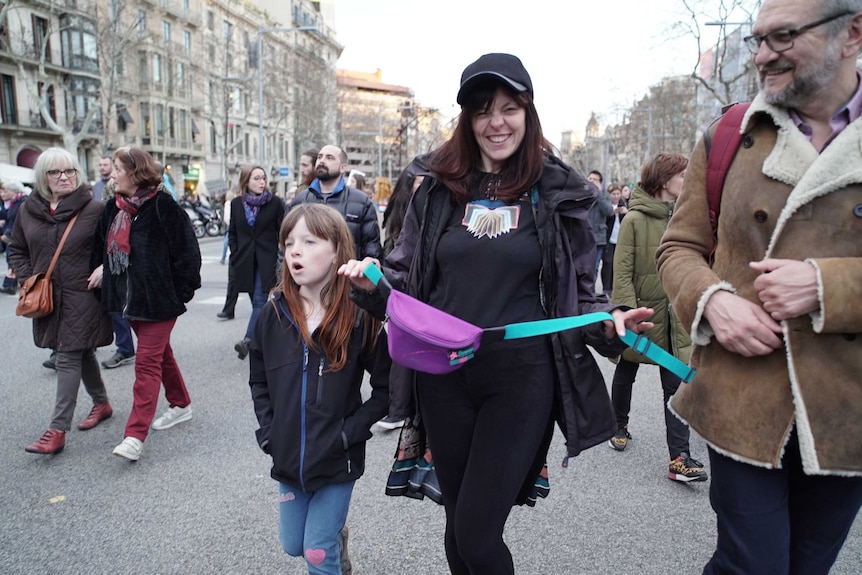 A mother and child walk side by side at the march.