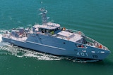 A patrol boat in the middle of the frame moving toward the right on a green-blue ocean