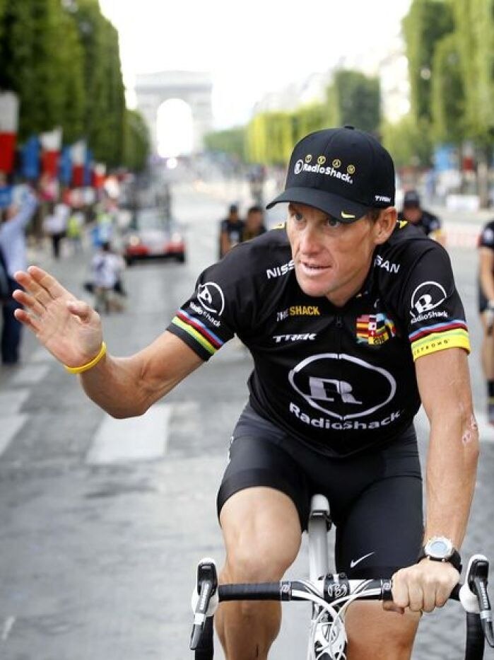 Lance Armstrong waves to the crowds on the Champs Elysees