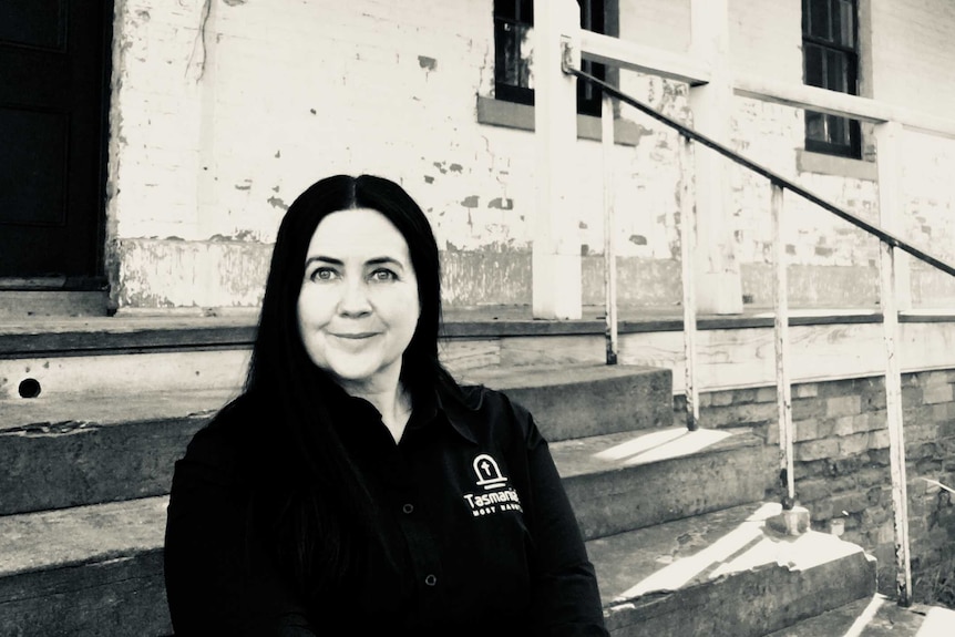 Black and white portrait of Tasmania's Most Haunted founder, Sharmaine Mansfield, in front of an old brick house