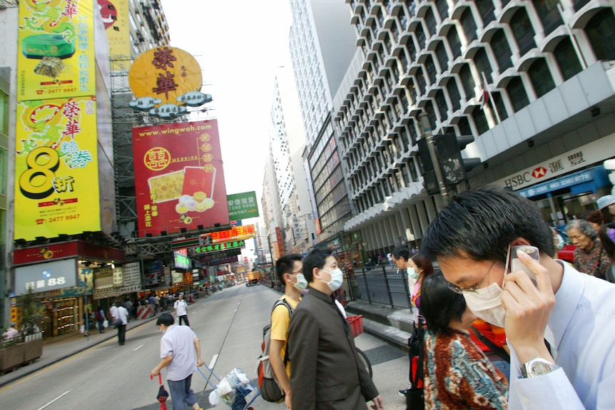 A man talks on his mobile phone whilst wearing a surgical mask in Hong Kong.