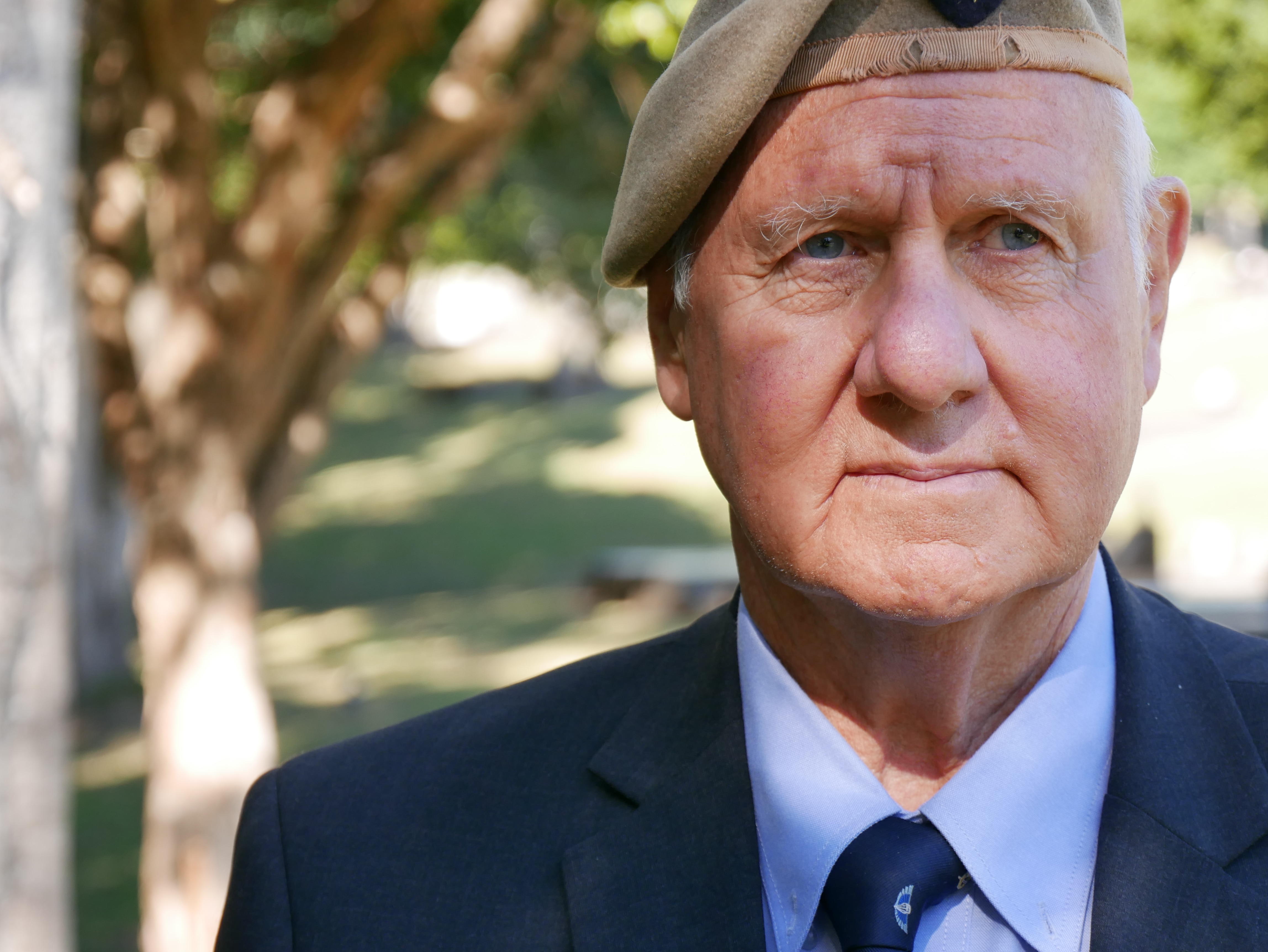 A closeup of the face of a senior man wearing an army beret.