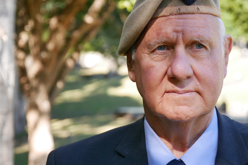 A closeup of the face of a senior man wearing an army beret.