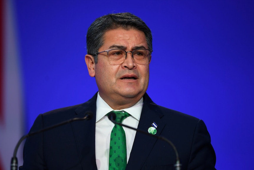 Honduras President Juan Orlando Hernandez speak from behind a lectern at COP26