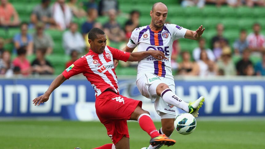 Melbourne Heart's Patrick Gerhardt challenges Perth's Billy Mehmet for the ball.