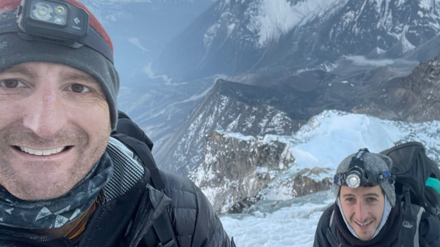 A selfie of a man wearing a beanie while on Mount Everest