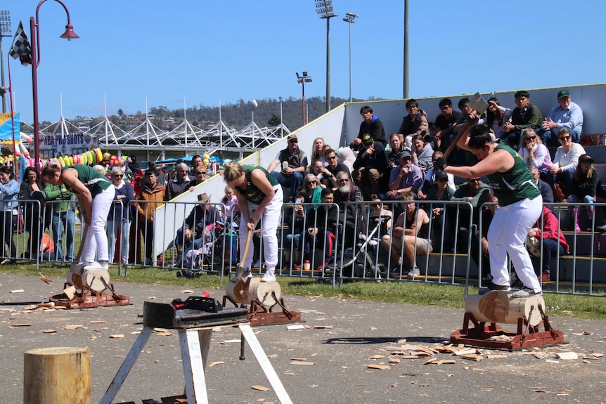 Women competing in an axe event at a showground.