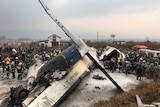 Rescue workers work around a plane wreckage.