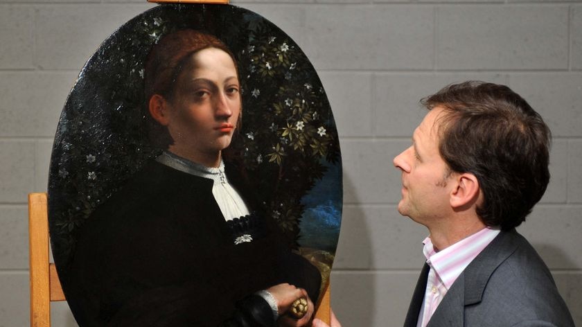 Mystery unravelled: NGV conservator Carl Villis views the portrait.