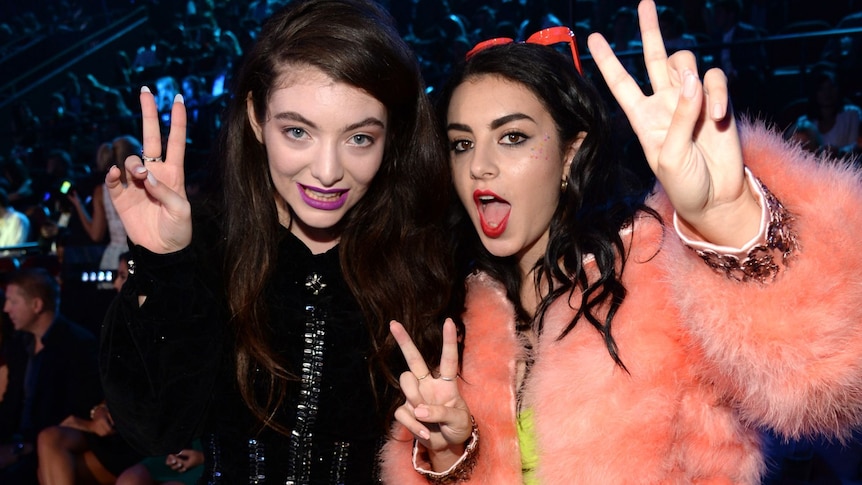 Lorde and Charli XCX throwing peace signs