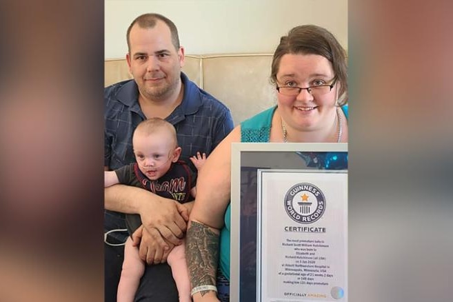 Beth and Rick Hutchinson at home with their son Richard holding the Guinness World Record certificate. 