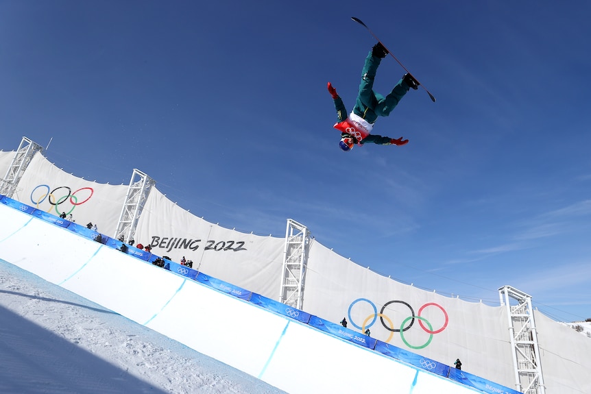 Scotty James is upside down as he flies through the air in the halfpipe