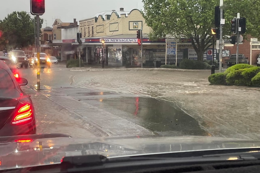 Floodwater flows across an intersection in a country town.