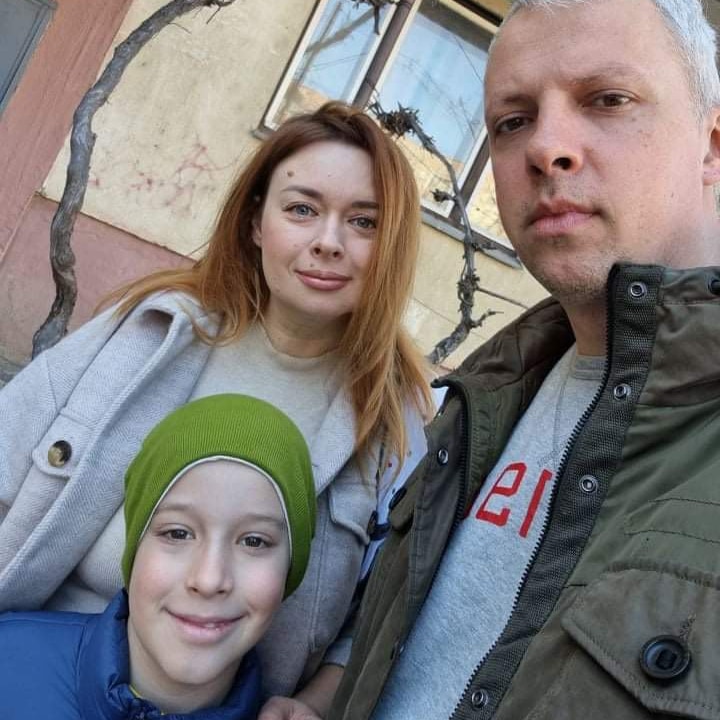 A selfie photo of a woman, man and young boy. 