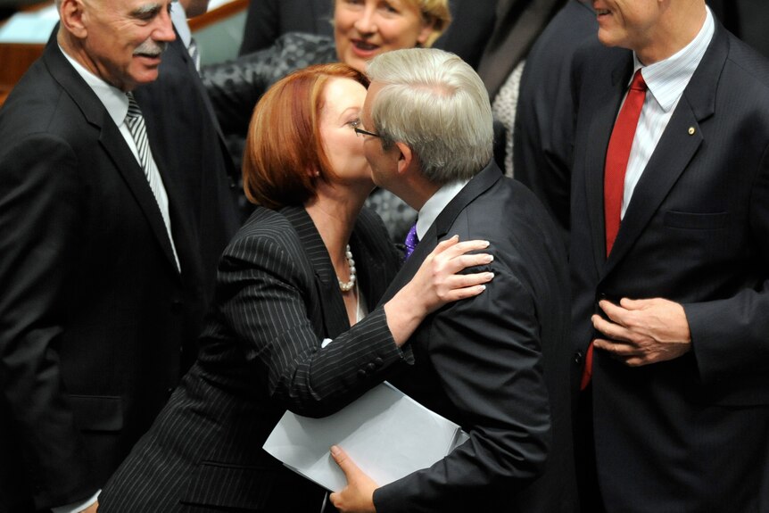 Julia Gillard hugs and kisses Kevin Rudd after the carbon tax legislation was passed in the House of Representatives in Canberra
