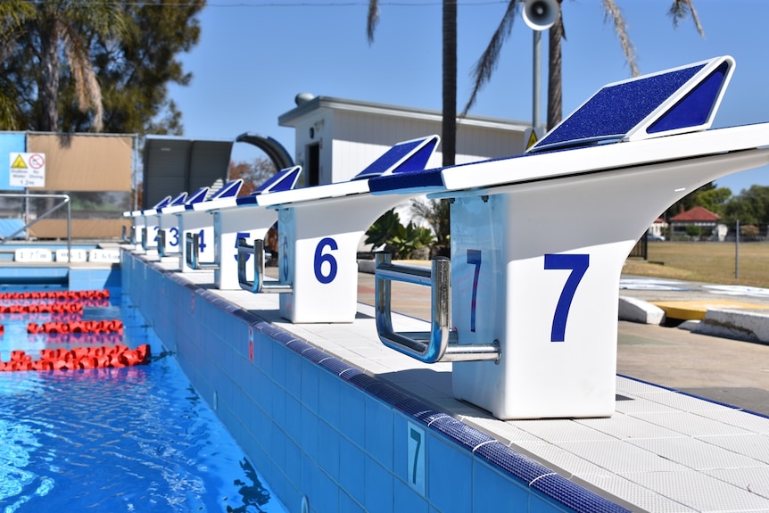 A close-up image of starting blocks and lane ropes at a public swimming pool