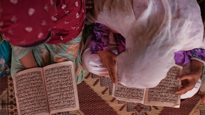 Internally displaced young girls from the Swat valley recite the Koran at a Madrassa in an IDP camp in Pakistan