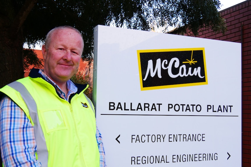 A man standing in front of a McCain sign