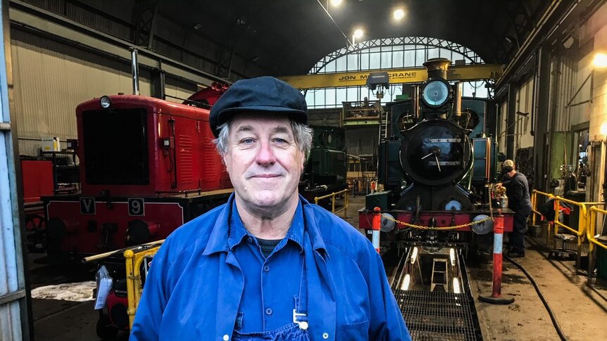Graham Hind stands in front of a steam train.