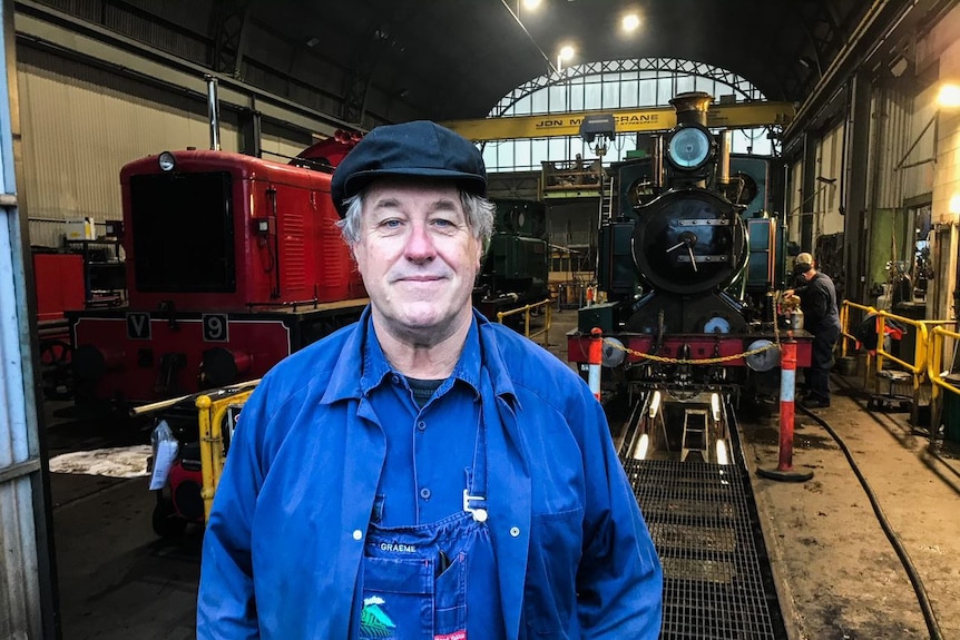 Graham Hind stands in front of a steam train.