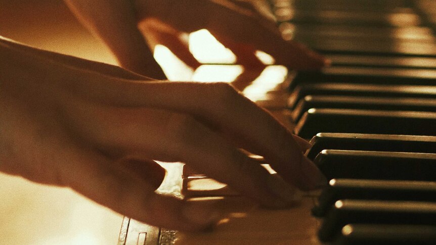 a closeup of hands playing a piano