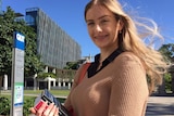 Hannah Taylor holds law textbooks outside a university.
