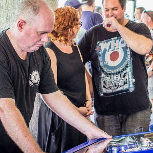 Man playing a pinball machine.