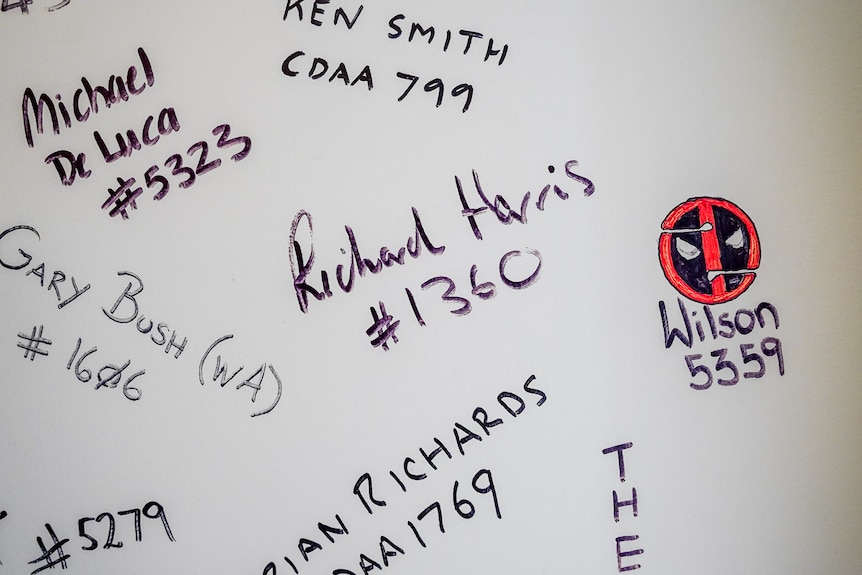 Le nom `` Richard Harris '' griffonné sur un mur blanc avec d'autres noms de plongeurs souterrains