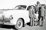 A family stands with their 1958 Holden