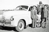 A family stands with their 1958 Holden