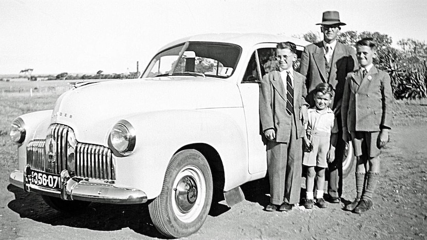 A family stands with their 1958 Holden