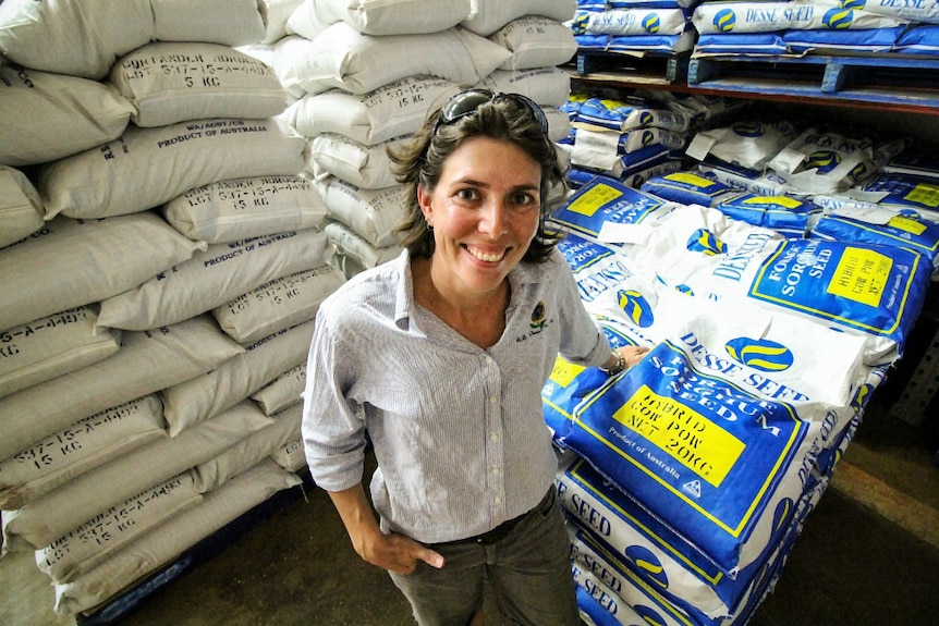 Kalyn Fletcher standing in front of seed bags at her family farm in Kununurra, Western Australia.