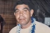 A man wearing a blue and white tinsel necklace