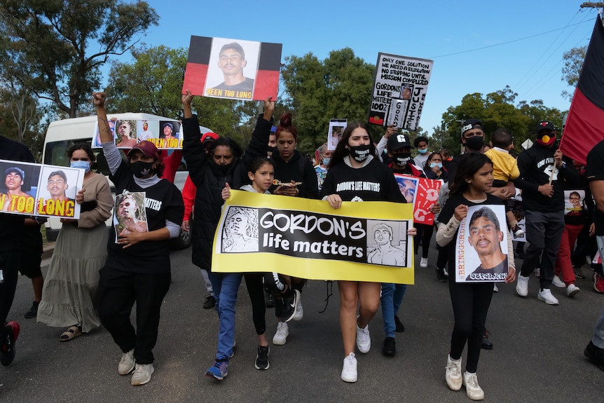 A public rally, one banner saying "Gordon's life matters".