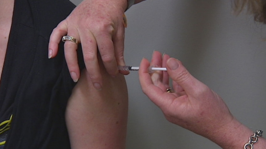 A person receiving a vaccine shot in their arm.