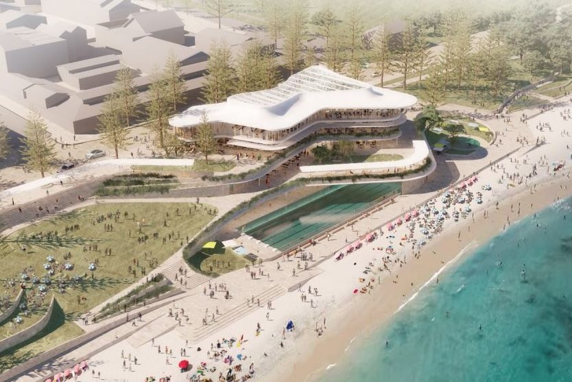 An aerial view shows a pool next to the beach, a wavy glass-fronted building looking out over the ocean.