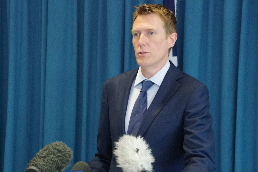Christian Porter speaks to journalists dressed in a blue suit, blue tie and blue shirt.