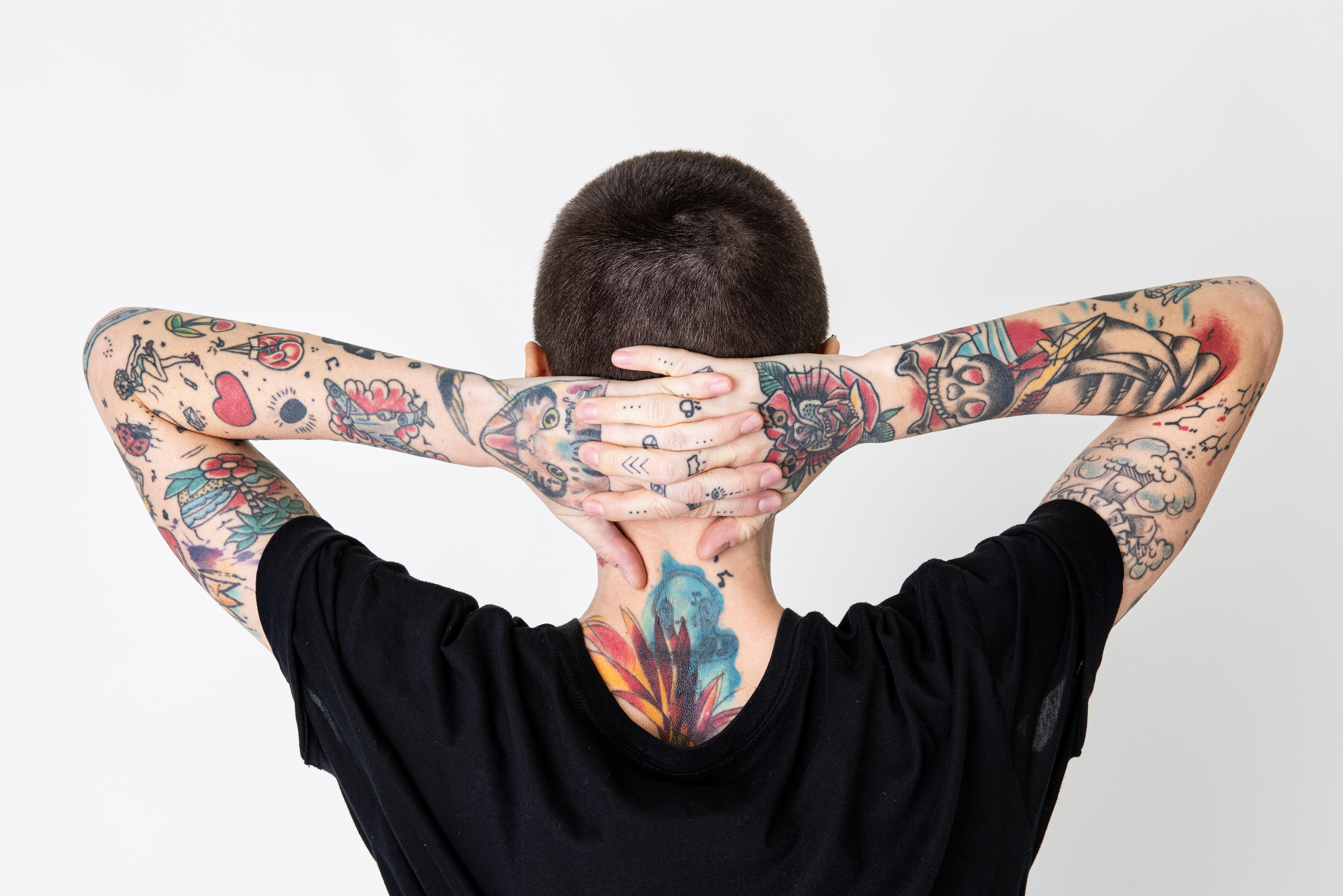 Persona tatuada de espaldas a la cámara. 