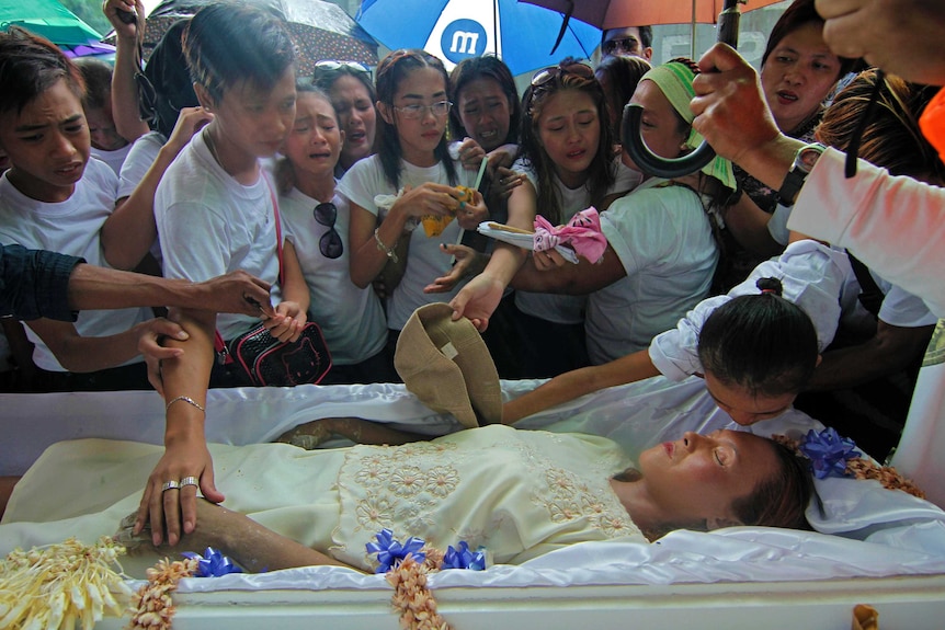 Mourners crowd around the casket of Leah Espiritu, a victim of the drug violence in Manila.