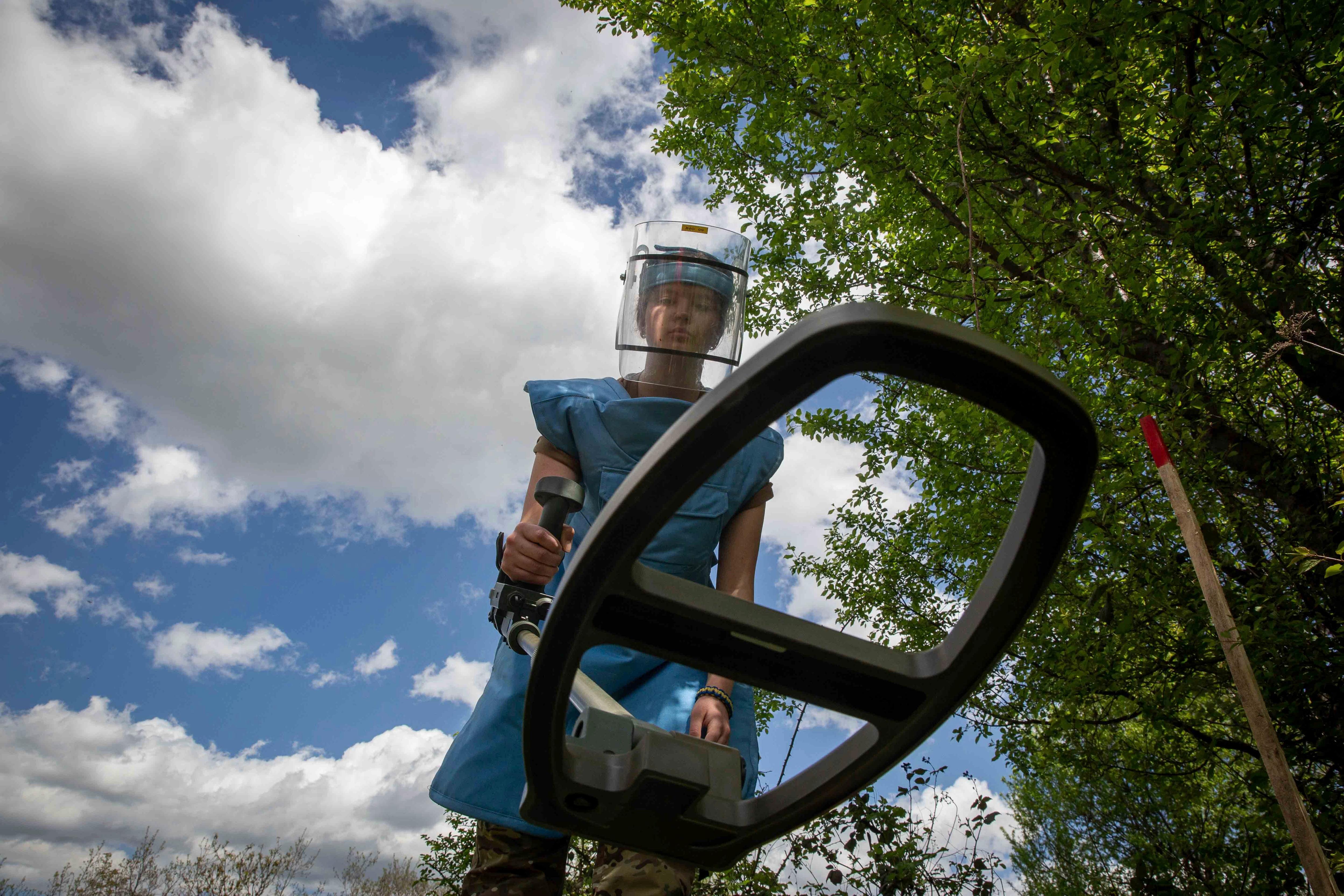 Anastasiia Minchukova sweeps with a mine detector during a training session.