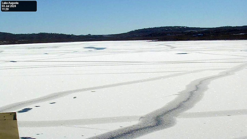 A lake frozen over on a clear day.