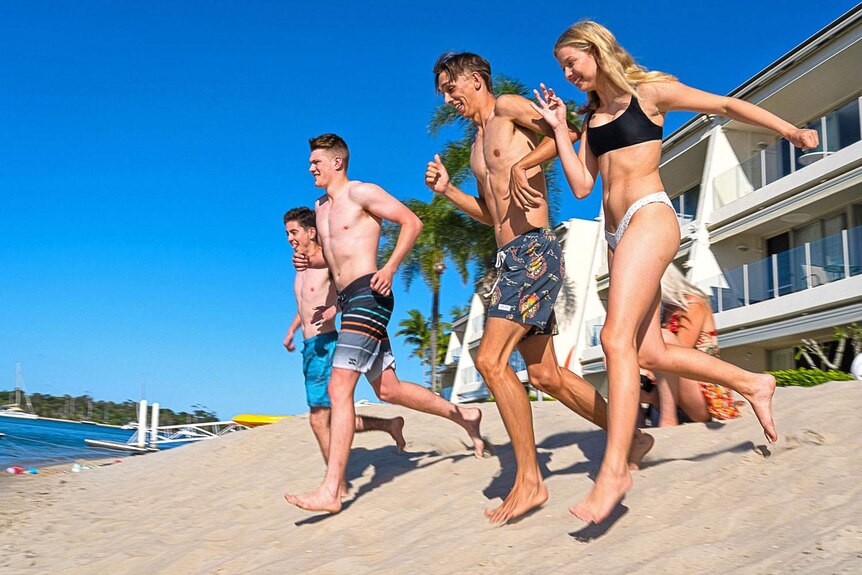 Connor Phillips (second from right) runs down the beach with three friends at Noosa.