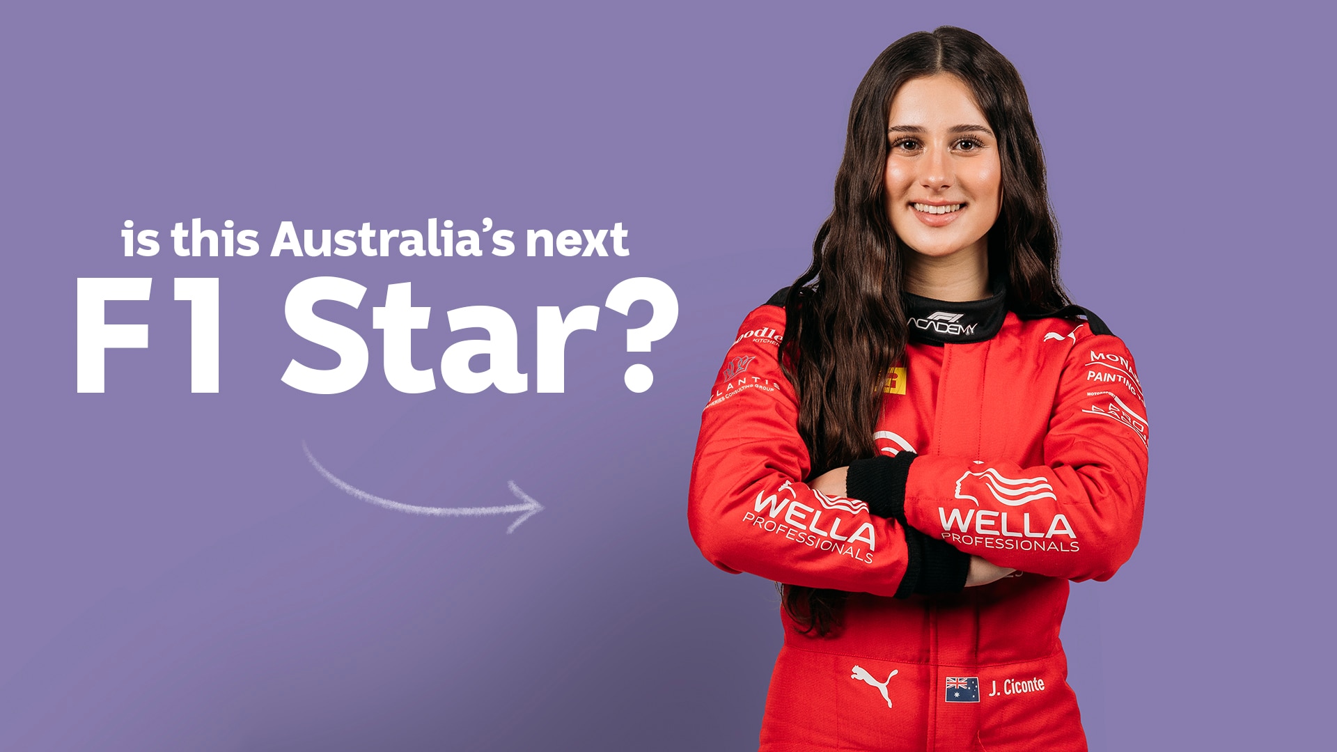 Joanne in car racing gear smiles to camera with arms crossed for a photoshoot.